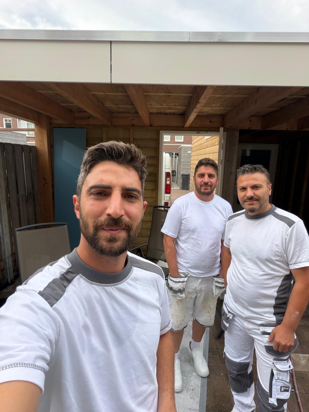 Drie leden van het klusteam bij een woning
